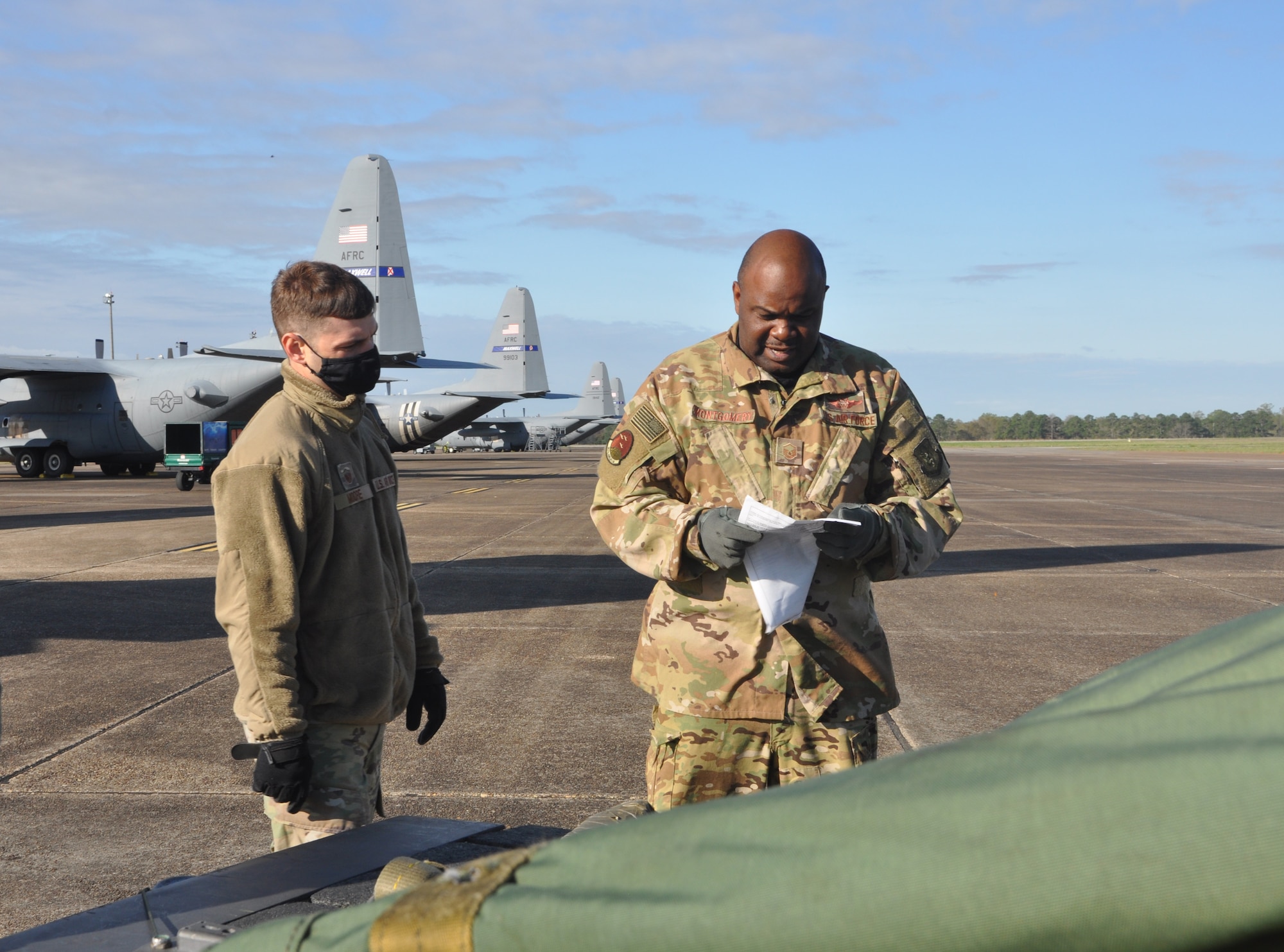 service members prepare to load cargo on an aircraft