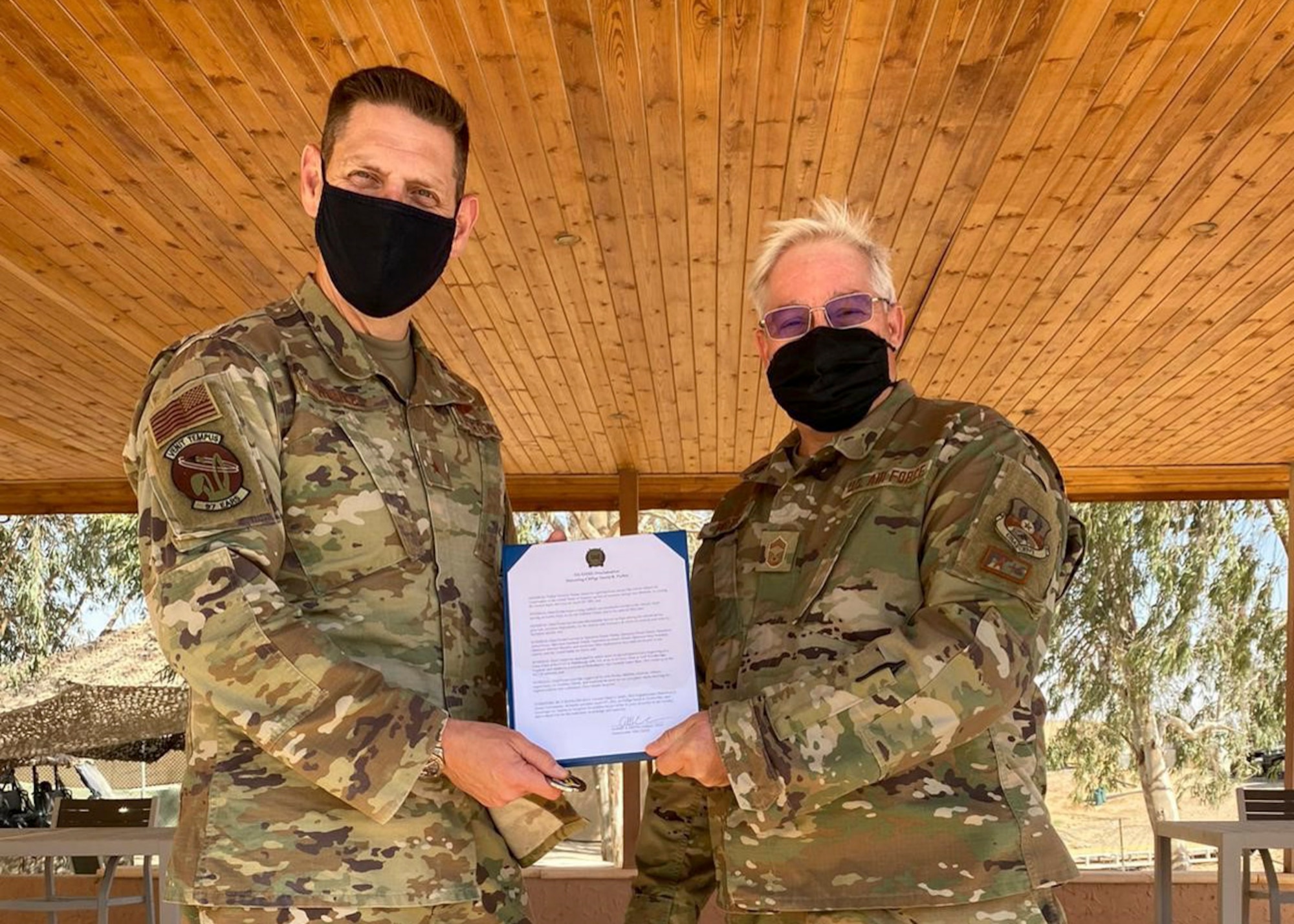 U.S. Air Force Brig. Gen. Joseph Kunkel, the commander of the 332nd Air Expeditionary Wing, presents a proclamation naming April 25, 2021, Chief Master Sgt. David Purtee day at the wing in honor of him crossing 40-years of service. Purtee is assigned to the 121st Air Refueling Wing in Columbus, Ohio, and is currently deployed to the wing at an undisclosed location in the Middle East. (Photo courtesy Chief Master Sgt. Jeff Vander Woude)