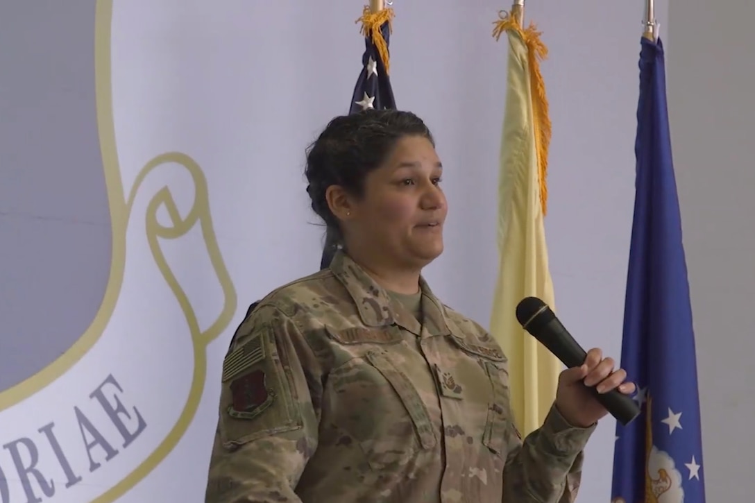 An airman speaks into a microphone.