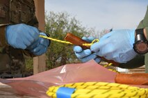 An Airman looping detonating cord through an explosive