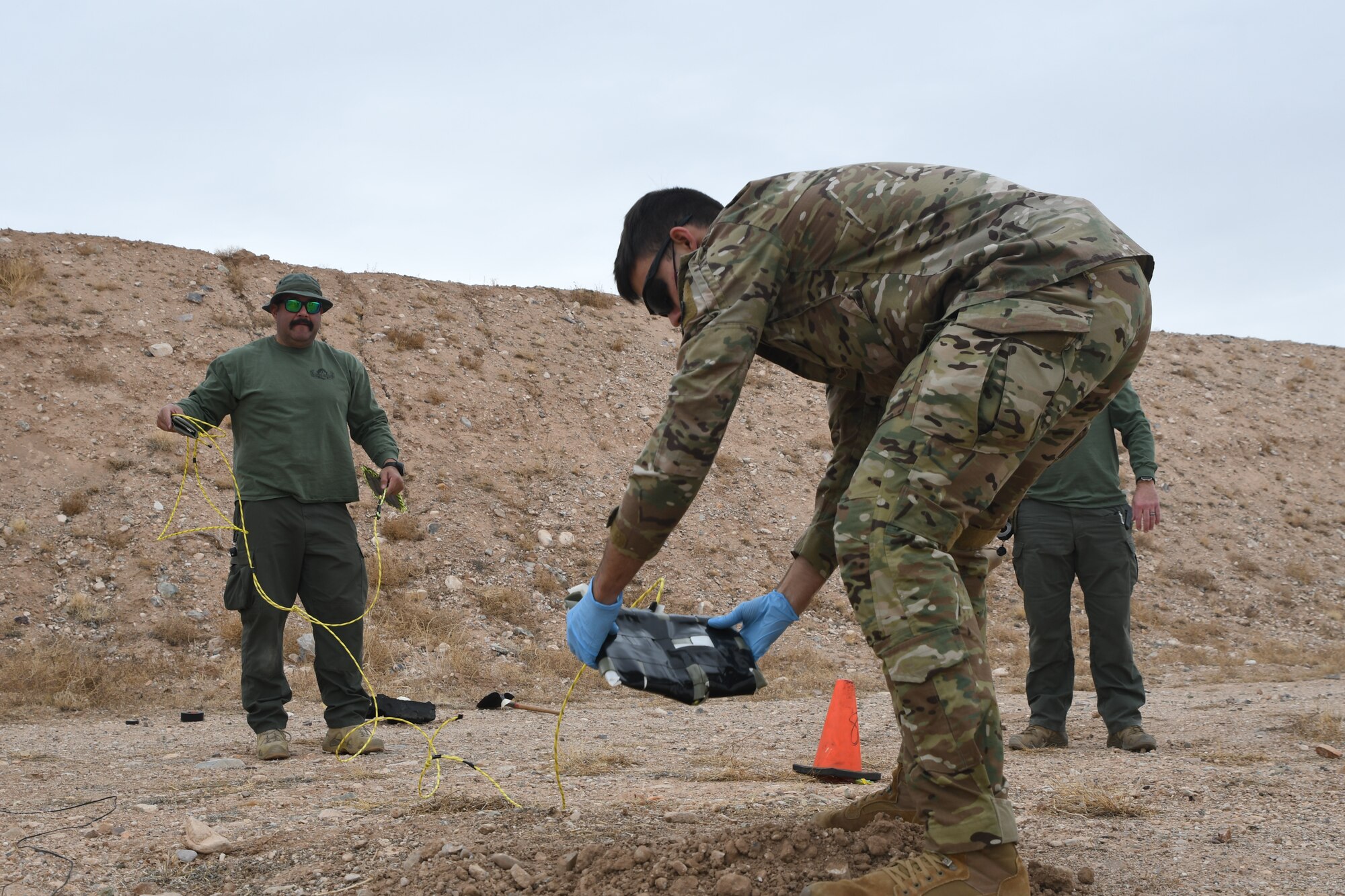 A picture of an Airman planting an explosive.