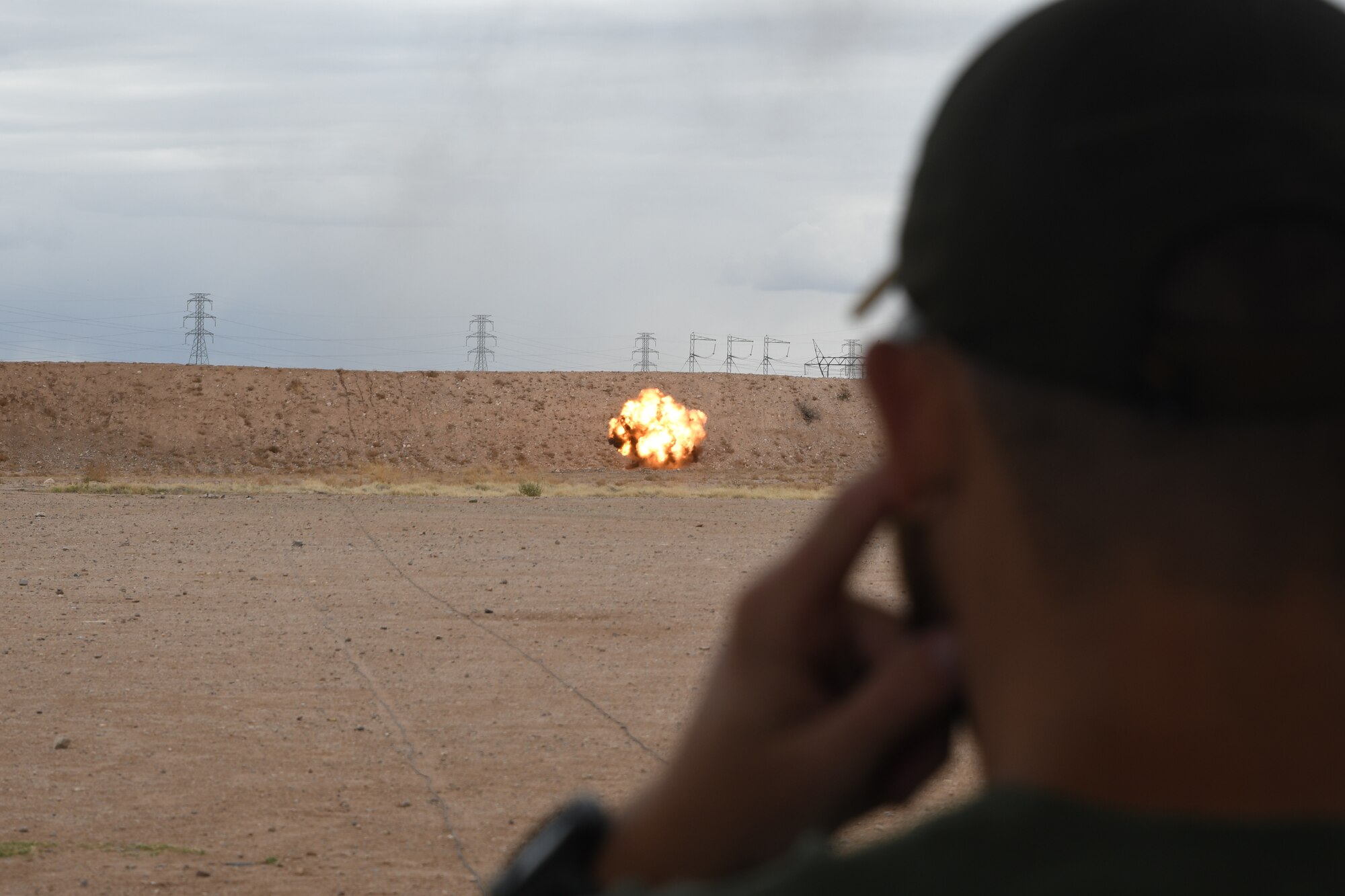 A picture of a man watching a detonation.