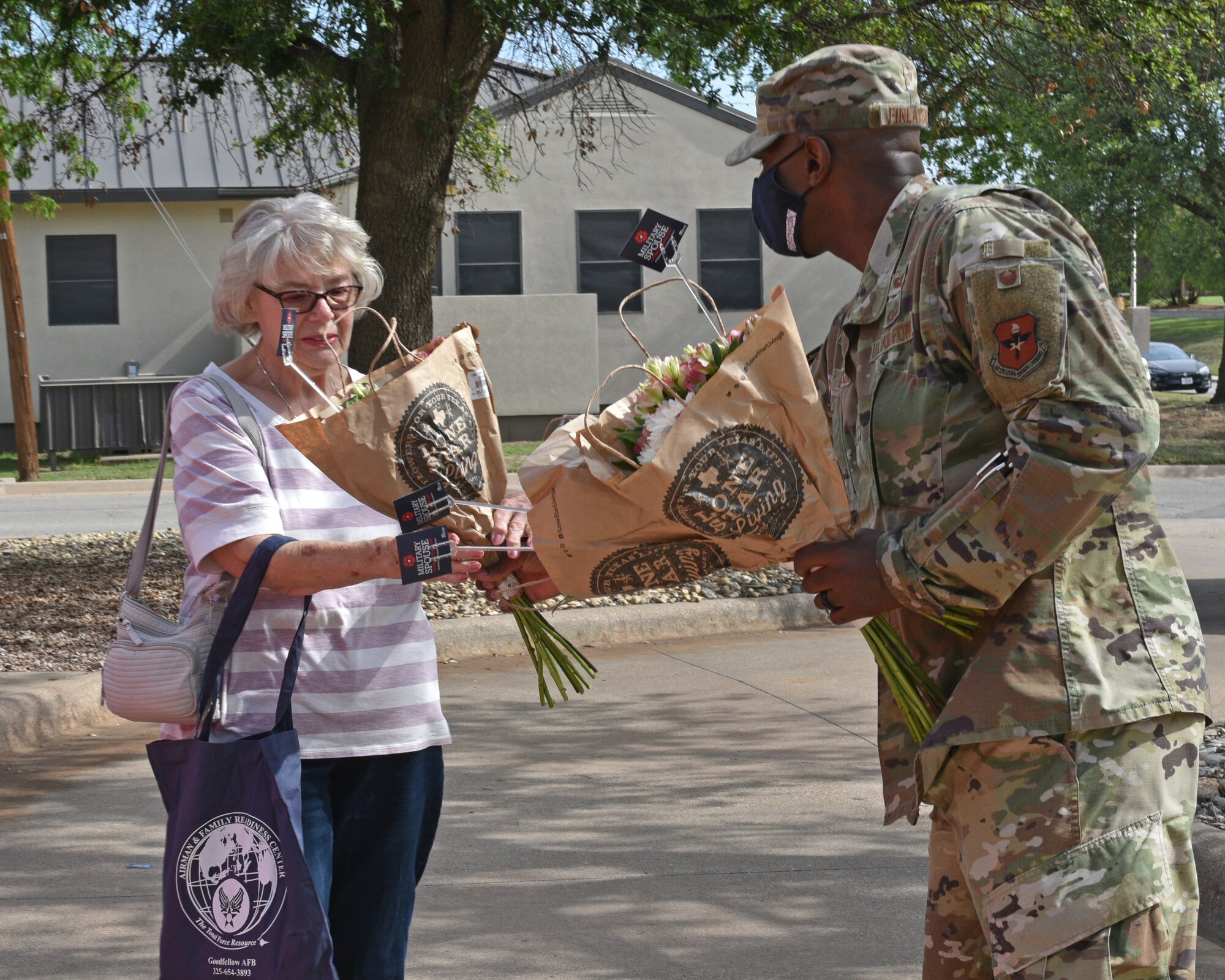 U.S. Air Force Col. James Finlayson, 17th Training Wing vice commander, gives flowers to Frauke Harrington, military retiree spouse, during the Military Spouse Appreciation Day Drive-Thru event at the Event Center on Goodfellow Air Force Base, Texas, May 7, 2021. Harrington’s spouse retired from the Navy, Air Force, and Air National Guard. (U.S. Air Force photo by Senior Airman Ashley Thrash)