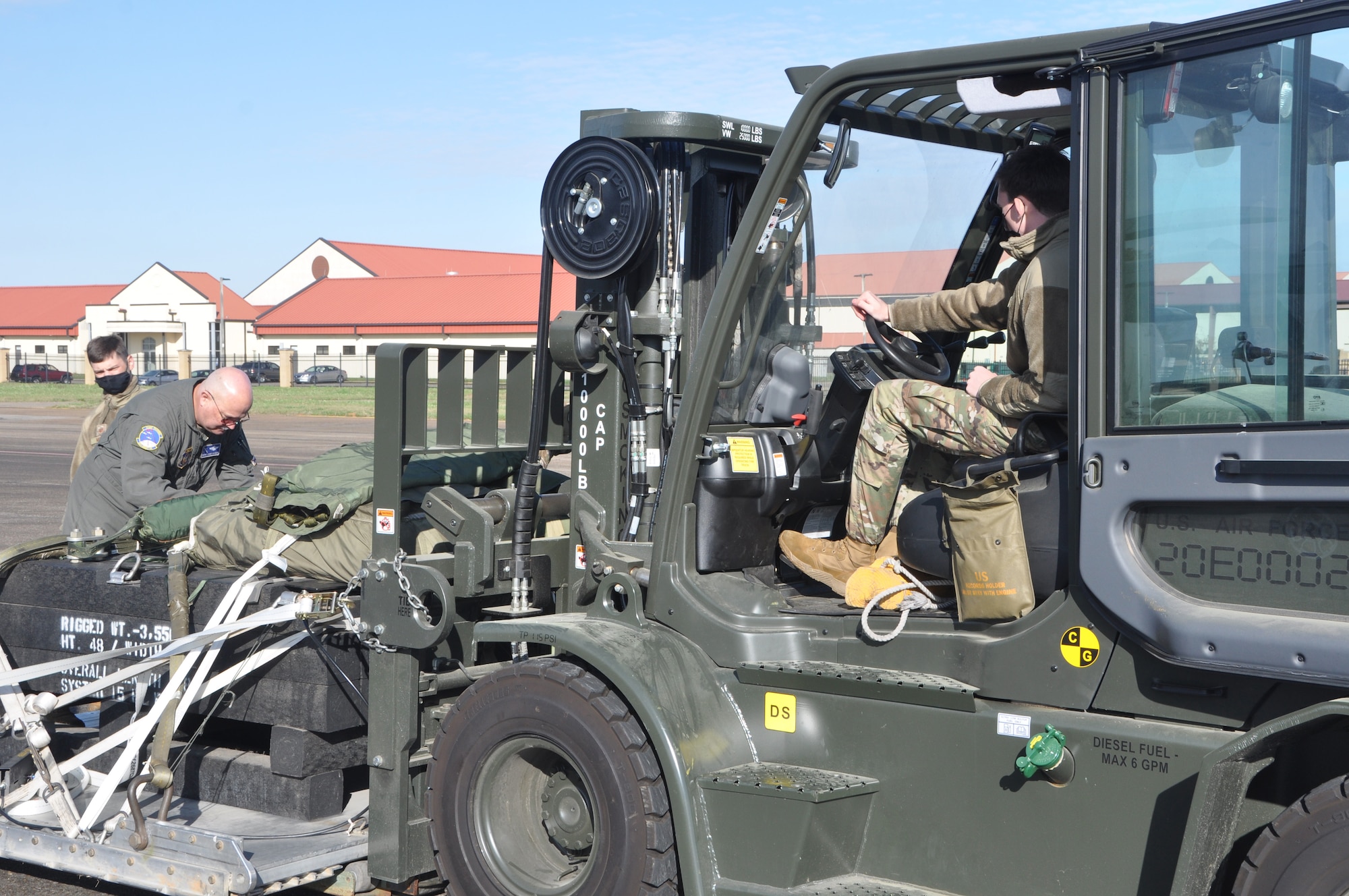 Service members prepare to load cargo on an aircraft