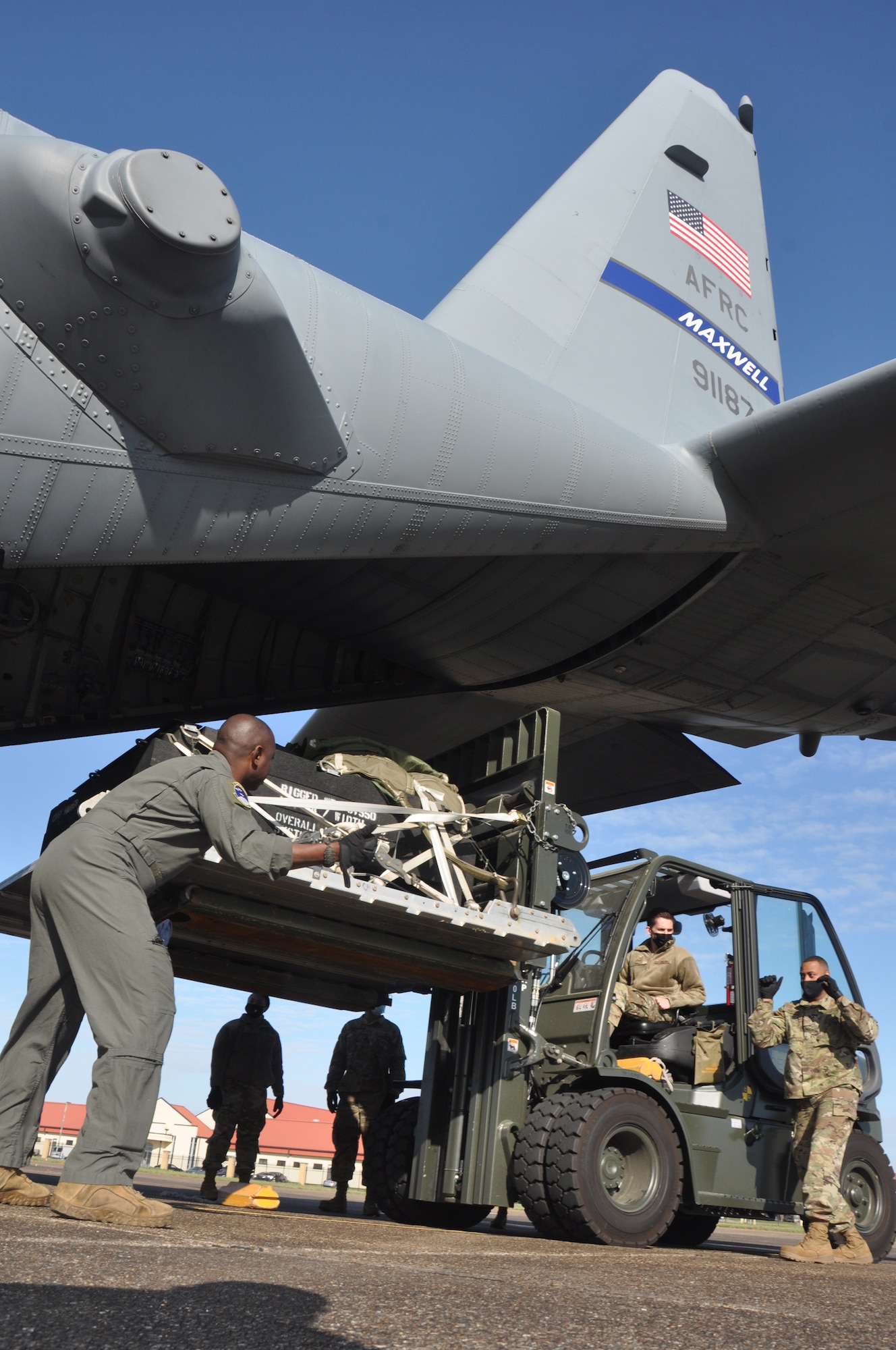 service members load cargo on an aircraft