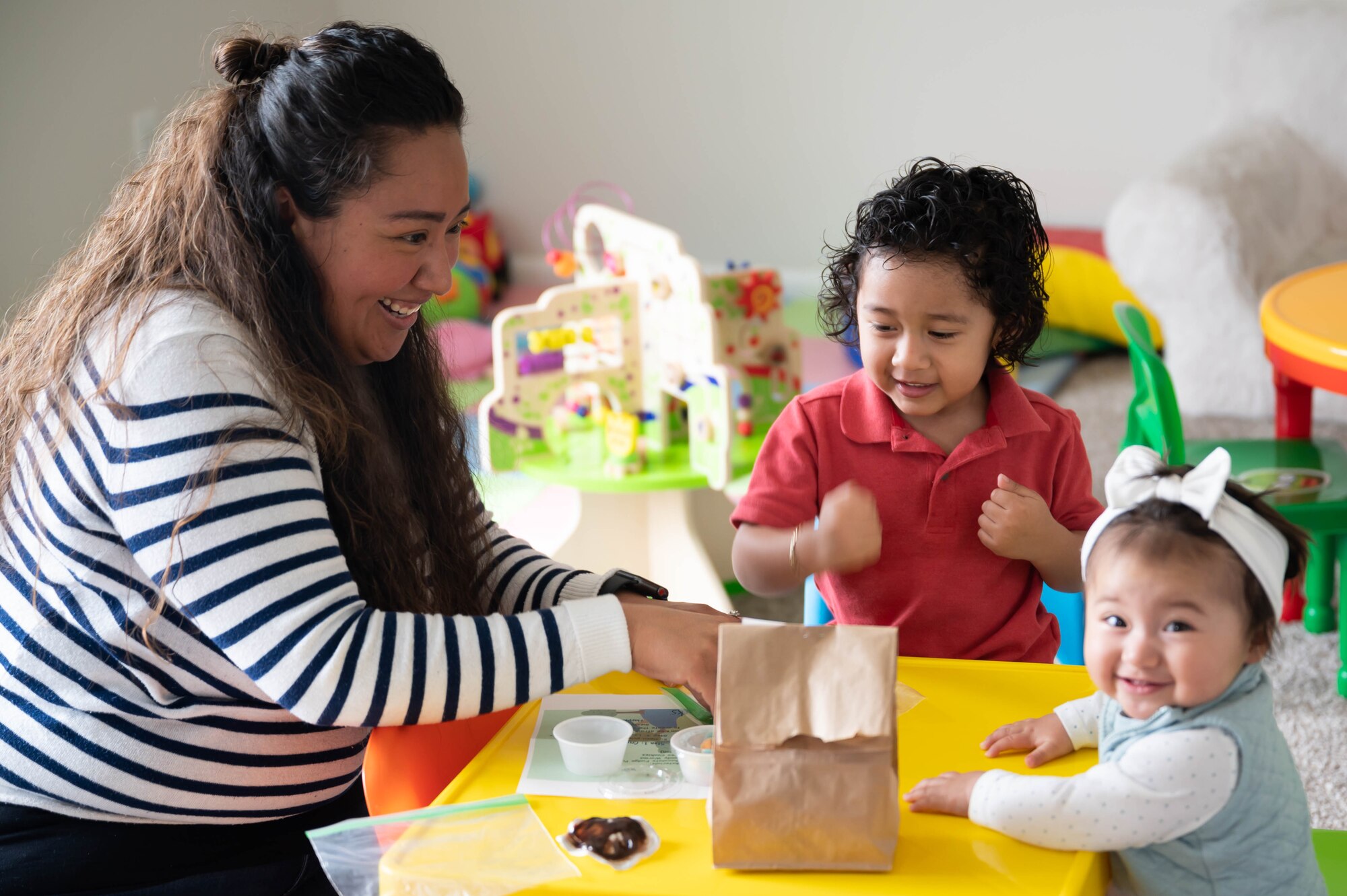 Iris Colon Salcido, left, stay-at-home mother and prospective Family Child Care provider, completes an Earth Day activity with her children three-year-old Luis Scalcedo, center, and 10-month-old Alessia Salcedo, April 22, 2021, at Malmstrom Air Force Base, Mont.
