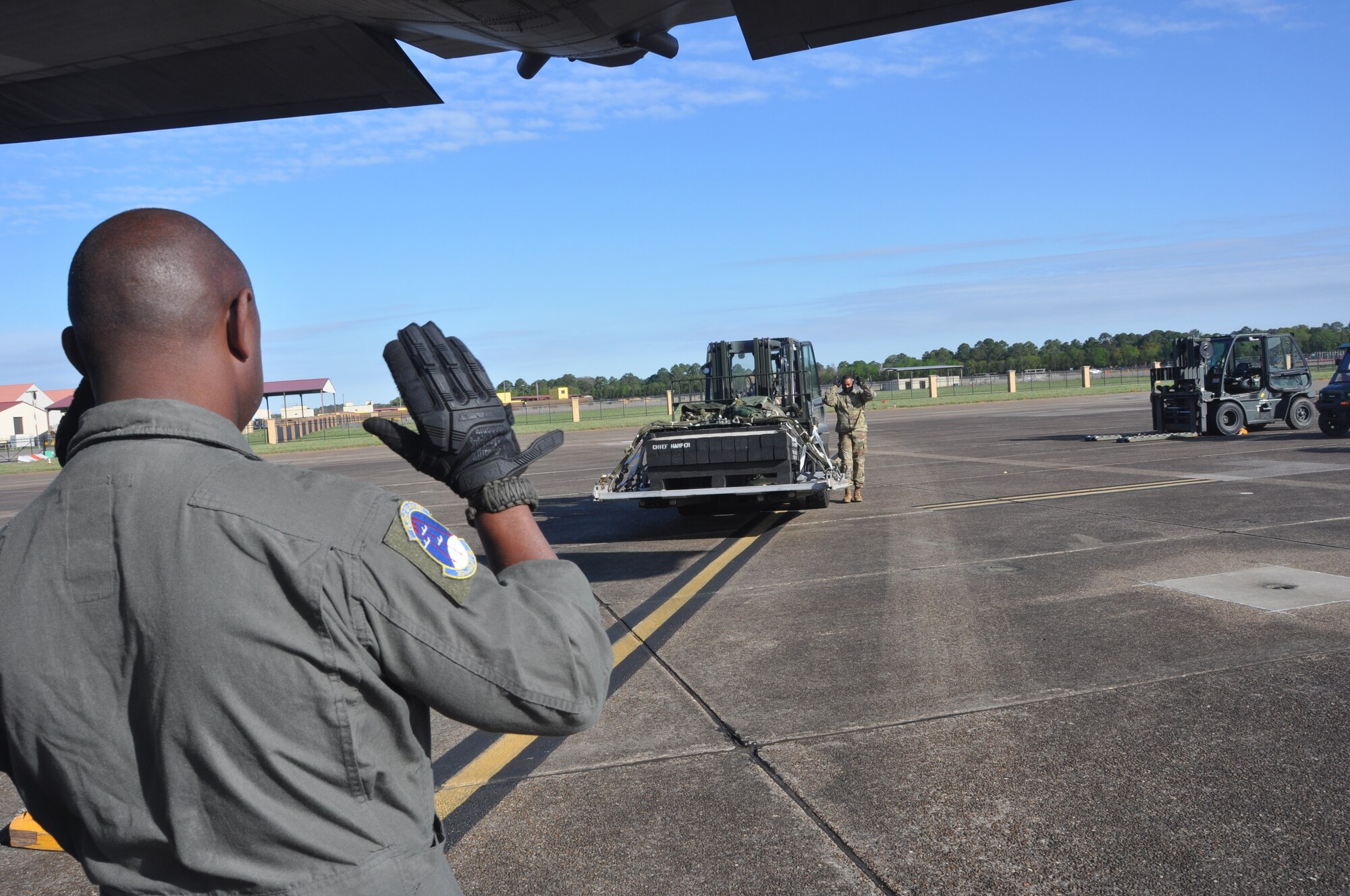 service members load cargo on an aircraft