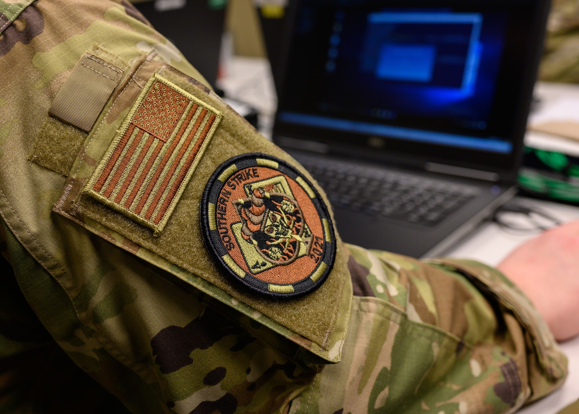 U.S. Air Force Staff Sgt. James Abeyta, a cyber warfare operator with the 275th Cyberspace Operations Squadron, Maryland Air National Guard, wears a Southern Strike 21 exercise patch while working on a computer April 21, 2021, at the Gulfport Combat Readiness Training Center, Gulfport, Mississippi.