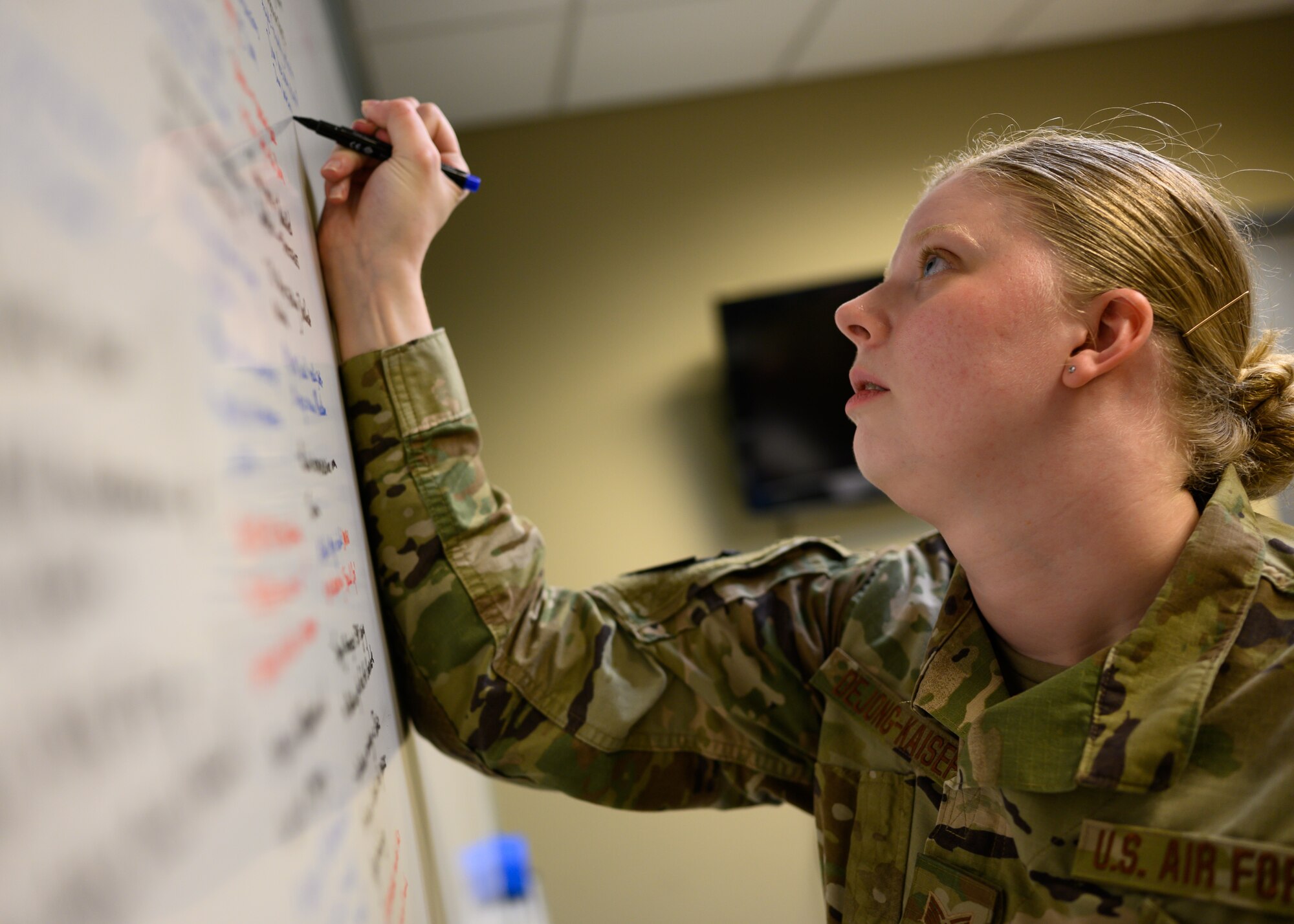 U.S. Air Force Staff Sgt. Gianna DeJong-Kaiser, an intelligence analyst for the 275th Cyberspace Operations Squadron, Maryland Air National Guard, lists out mission details on a whiteboard April 21, 2021, at the Gulfport Combat Readiness Training Center, Gulfport, Mississippi.