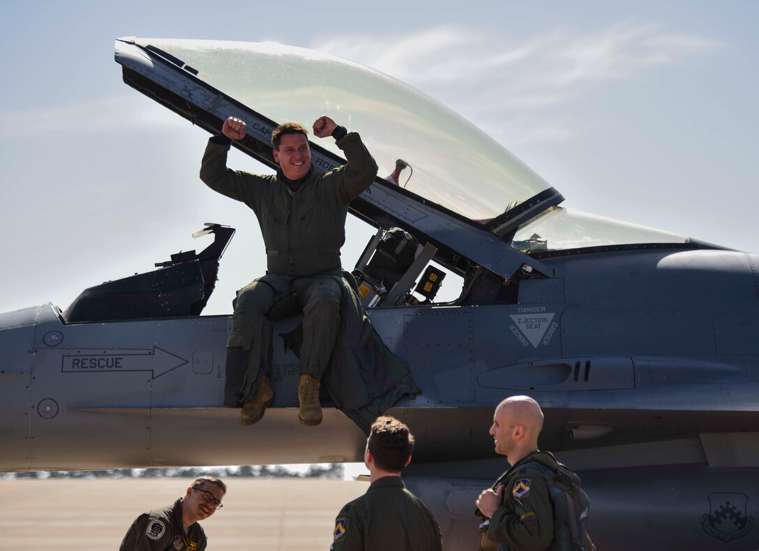 man sitting on a jet flexing his muscles