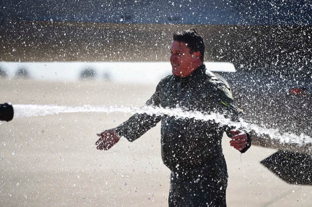 man getting sprayed with hose water