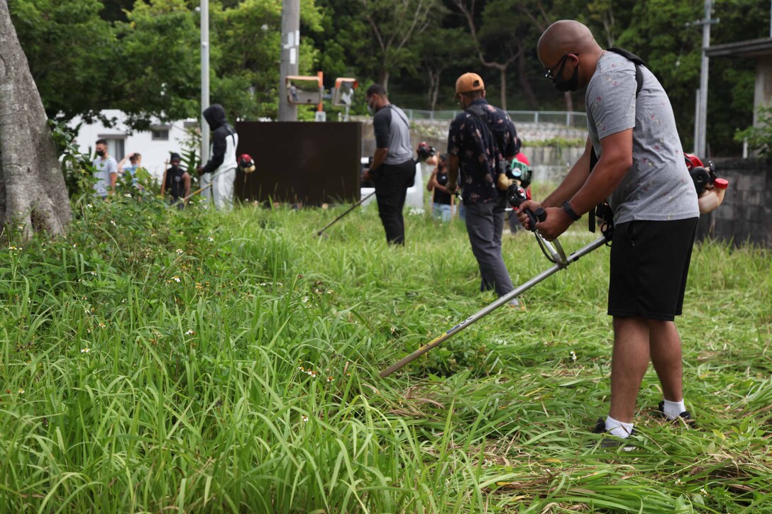 金武町にある「屋嘉ビーチ前」バス停近くの一画で、草刈り作業に励む第３１海兵遠征部隊の海兵隊員たち、２０２１年５月８日、沖縄県金武町