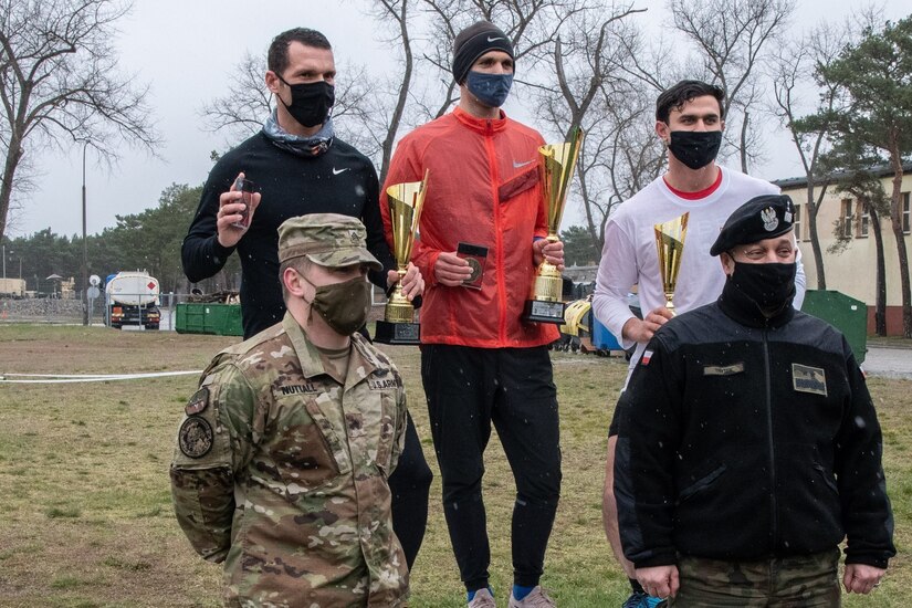 U.S. Army Reserve Sgt. Joseph Nuttall, bottom left, noncommissioned officer for Civil Affairs Team 5737, 457th CA Battalion, 361st CA Brigade, 7th Mission Support Command, and Maj. Gen. Piotr Trytek, bottom right, commander of Poland’s 11th Armored Cavalry Division, pose with the top three finishers of the inaugural Better Opportunities for Single Soldiers Poland event, a 5K competition held at Zagan Forward Operating Station, Poland, April 15, 2021. BOSS Poland is the first-ever BOSS program to be established for deployed and rotational troops, instituted by Nuttall and his U.S. Army Reserve civil affairs team. (Photo by Maj. Marcellus Simmons, 1-1 ABCT Public Affairs)