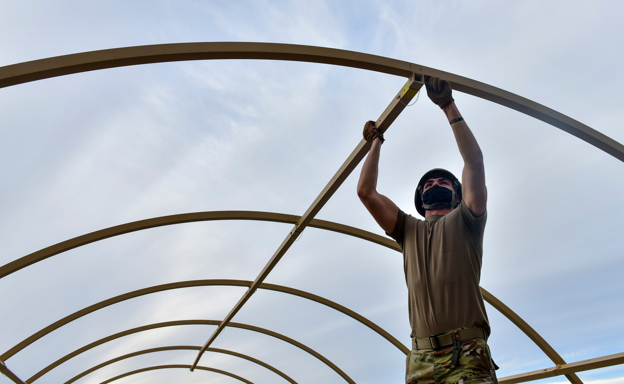 An Airman assigned to the 19th Airlift Wing assembles a military shelter system