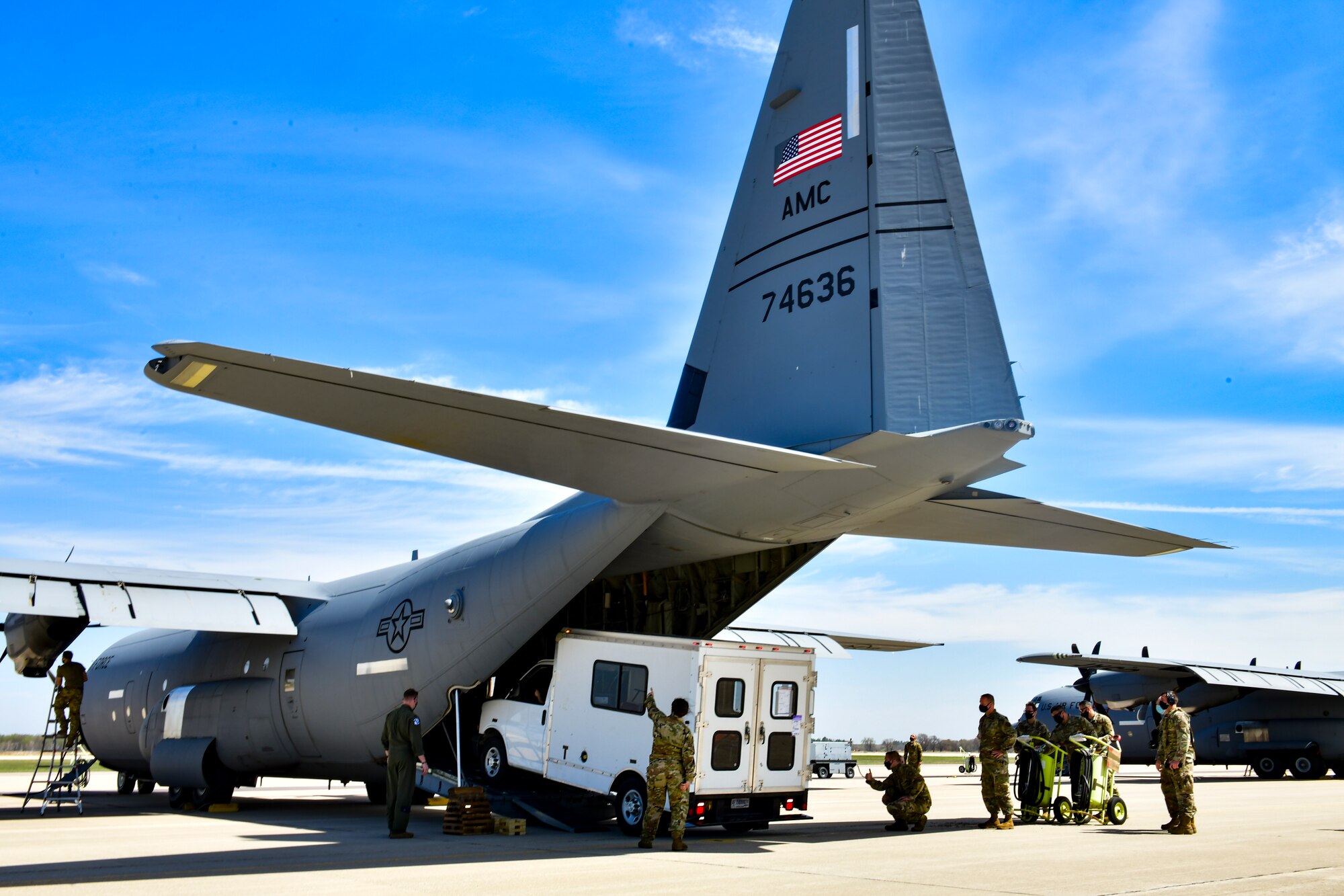 Airmen assigned to the 19th Airlift Wing offload a vehicle from a C-130J Super Hercules