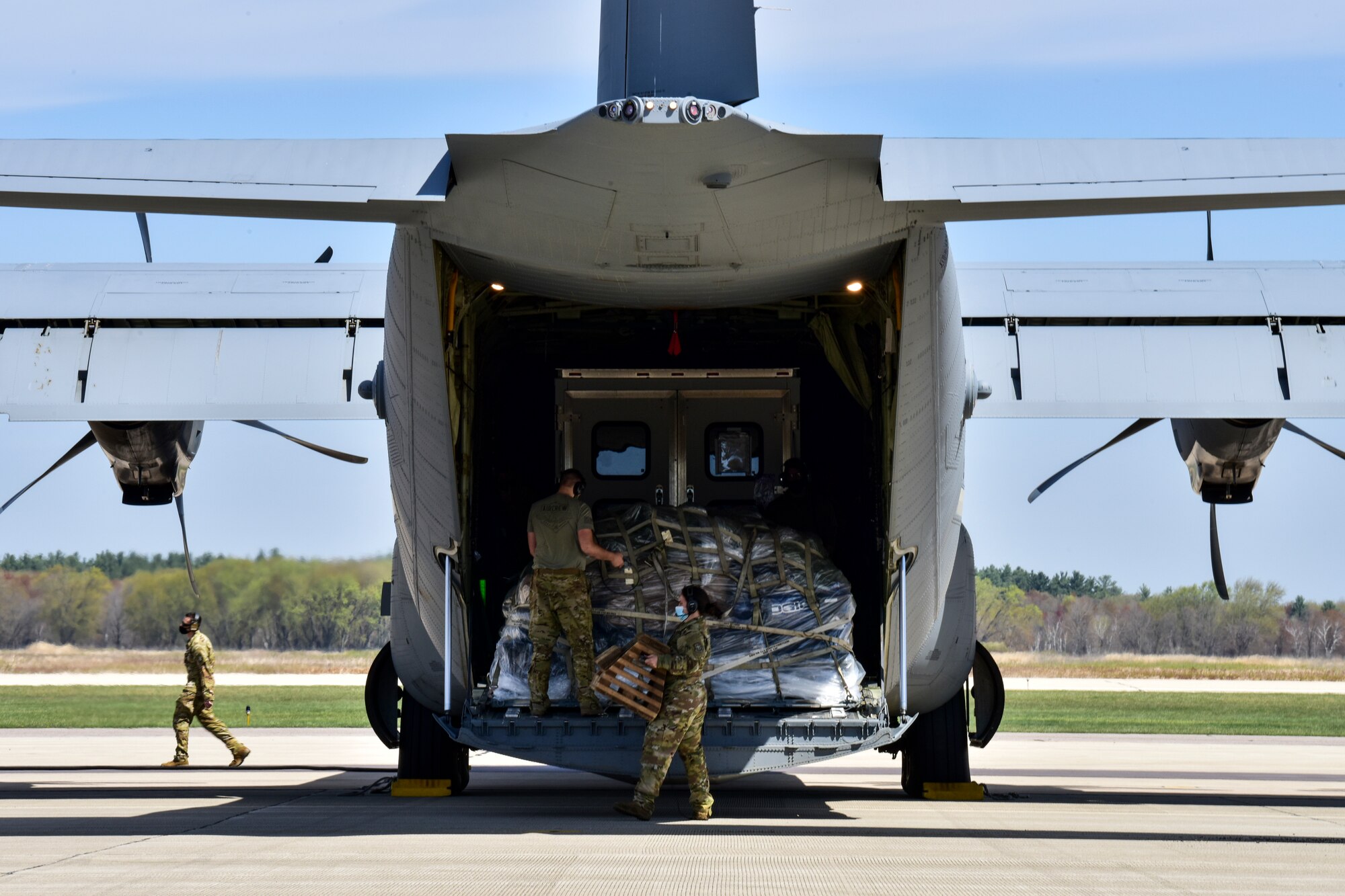 Airmen assigned to the 61st Airlift Squadron prepare to offload cargo from a C-130J Super Hercules
