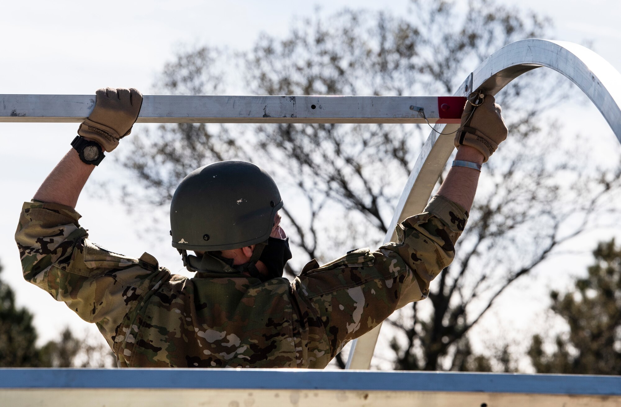 An Airman assigned to the 19th Airlift Wing assembles a military shelter system