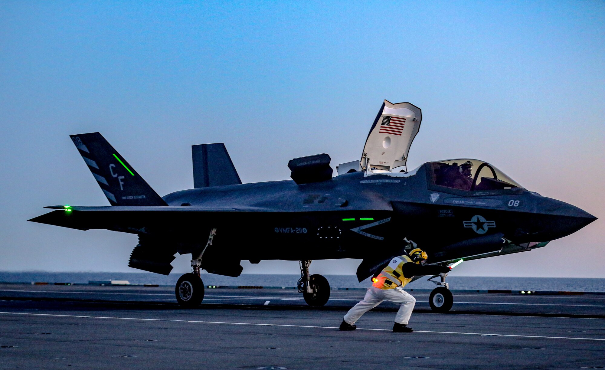 A Marine with Marine Fighter Attack Squadron 211, Carrier Strike Group 21, launches an F-35B Lightning II aboard HMS Queen Elizabeth at sea, May 6, 2021. VMFA-211 was conducting night carrier qualifications to safely reintegrate back into the CSG. VMFA-211 will form part of the largest 5th-generation carrier air group in the world. This deployment highlights the global reach of the U.S. and UK armed forces and their interoperability, and enhances the deterrence and defense capabilities of the NATO Alliance.