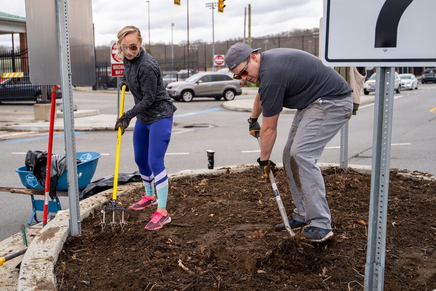 210417-N-EJ843-0005 GROTON, Conn. (April 17, 2021) Sarah Simons removes old soil before planting new plants outside of Naval Submarine Base (SUBASE) New London. The Simons’ started a beautification project on base after seeing trash and the need for improvement in certain areas. With a love for finding ways to make the community look better, the Simons’ noticed the outside of the base didn’t have many flowers or shrubs. After talking to SUBASE Public Works, the Town of Groton, and the state Department of Transportation they received approval for their beautification project near the base’s Main Gate. (U.S. Navy photo by Mass Communications Specialist Seaman Jimmy Ivy III/Released)