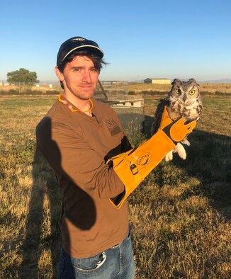 Tyler Adams, a US Department of Agriculture wildlife biologist at Hill AFB, displays an owl captured near the base's flight line. The bird will be taken to a new habitat as part of the Raptor Relocation Program, which focuses on trapping kestrels, hawks, owls, and other raptors and relocating the birds to safer and more suitable habitats away from the airfield.