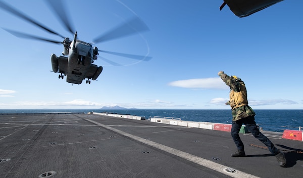 Aviation Boatswain’s Mate (Handling) 3rd Class Scott Kibler directs a CH-53E Super Stallion helicopter.