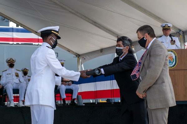 Jesse Mendez presents Lt. Justin Woods, the first officer of the deck of USS Miguel Keith (ESB 5), with a long glass during the ship’s commissioning ceremony.