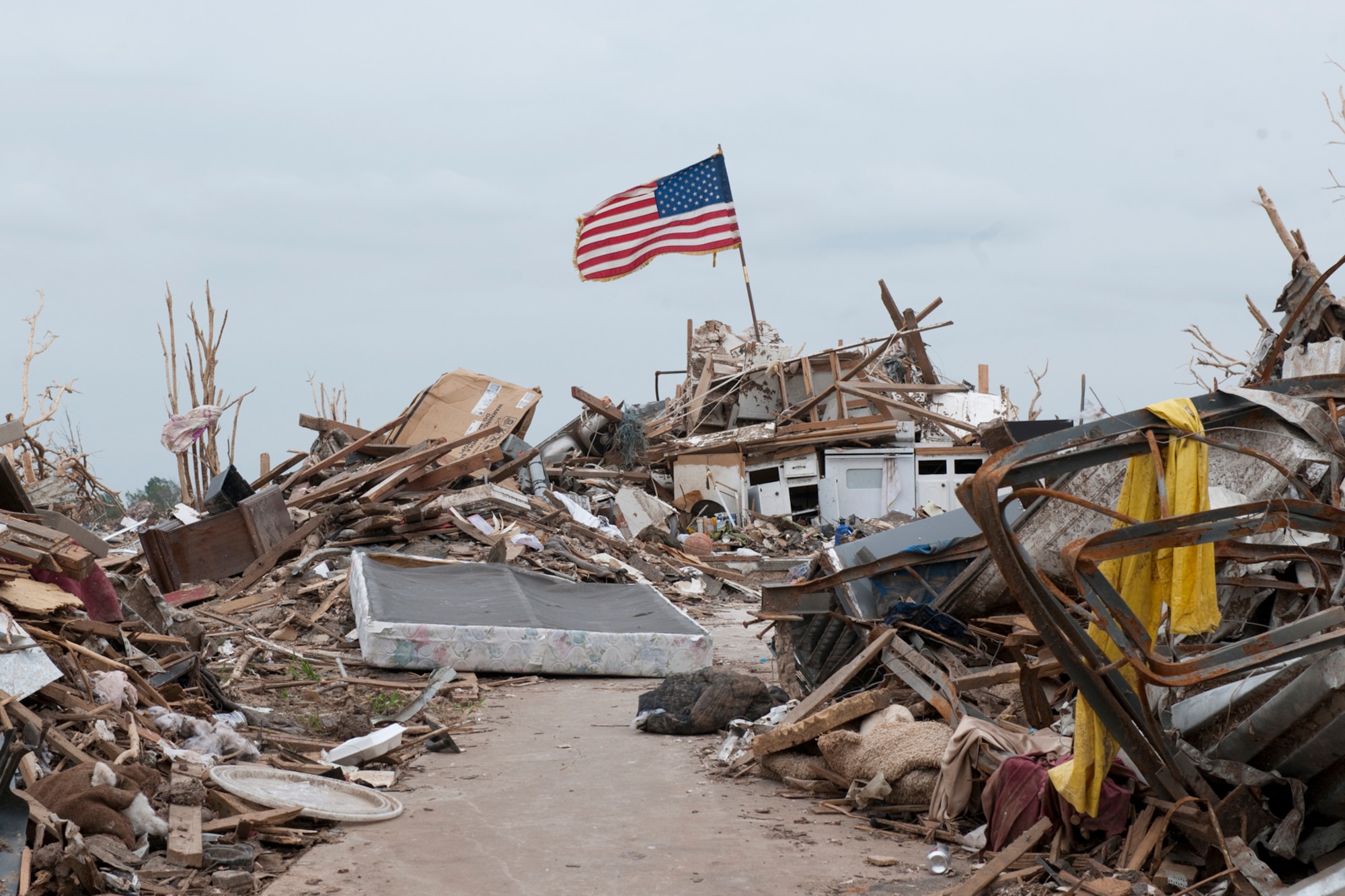 The U.S. flag standing atop mounds of debris where homes were destroyed by a tornado.