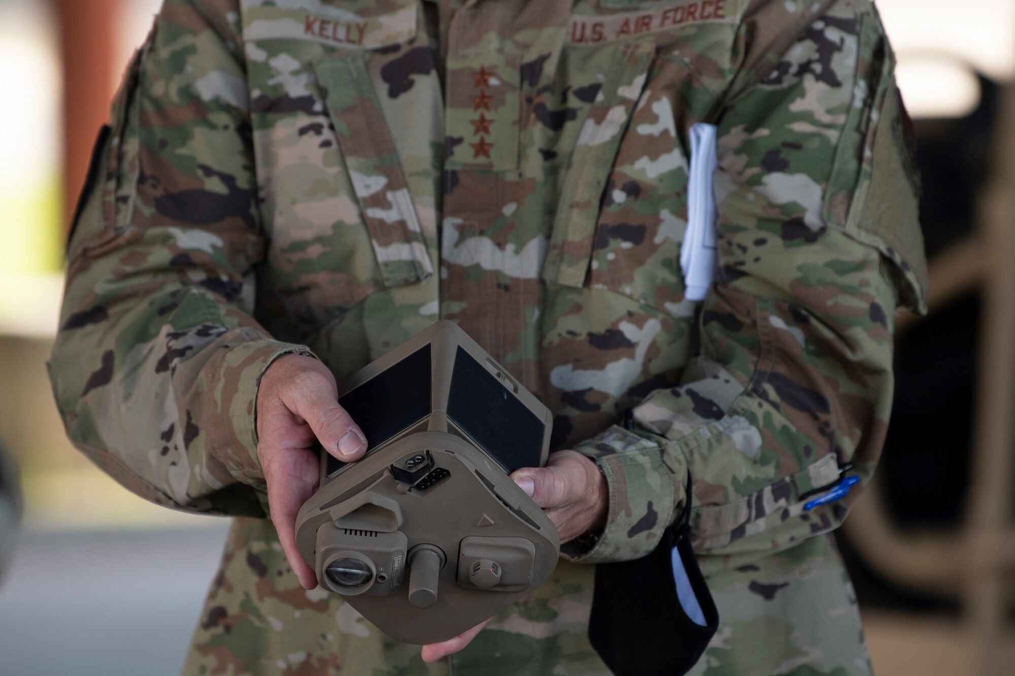A photo of Gen. Kelly holding a micro weather sensor.