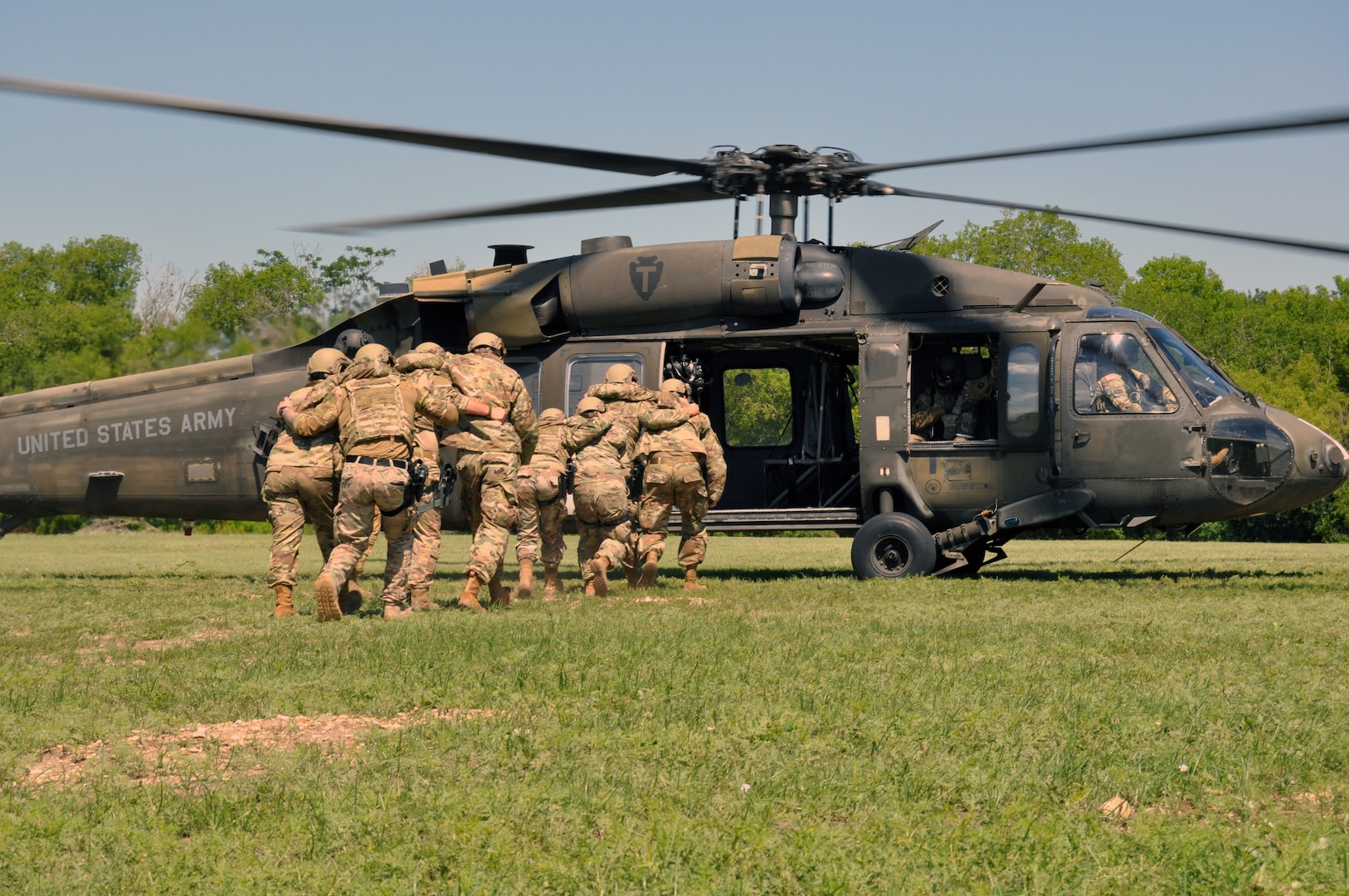 Airmen load simulated injured Airmen onto helicopter.