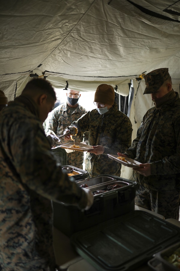 U.S. Marines participating in Arctic Care 2021 receive chow prepared by food service specialists with Combat Logistics Regiment 45, 4th Marine Logistics Group, during Arctic Care 2021 in Kodiak, Alaska, on May 6, 2021. Arctic Care 2021 is a joint-service training mission led by the United States Air Force and supported by members of the Air National Guard, Marines, Marine Reserves, Navy, Navy Reserves, National Guard, and Army Reserves. (U.S. Marine Corps photo by Lance Cpl. James Stanfield)