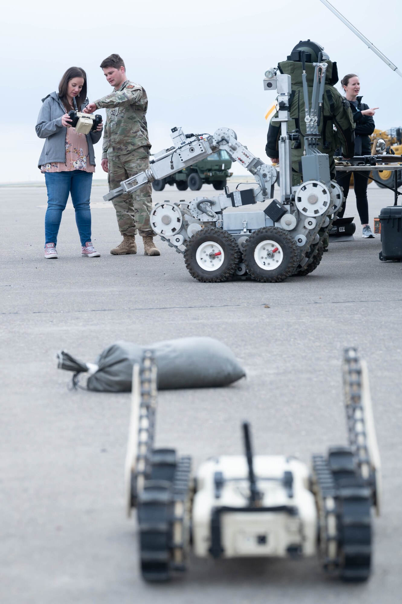 Senior Airman Ryan Gildehaus, right, 341st Civil Engineer Squadron explosive ordinance disposal technician, shows Nicole Nelson, military spouse, how to use an EOD robot during a tour May 7, 2021, at Malmstrom Air Force Base, Mont.