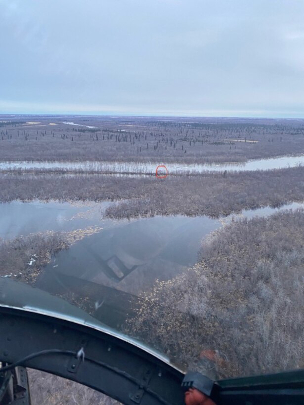 The location (circled in red) of four stranded boaters on the Kuskokwim River is visible from the windshield of a UH-60L Black Hawk helicopter from 1st Battalion, 207th Aviation Regiment, Alaska Army National Guard, May 10, 2021. The helicopter aircrew rescued the four individuals and their dog after they became stuck on the river between Bethel and Kwethluk because of ice from break up blocking their egress. All four individuals and their dog were hoisted into the helicopter and transported back to Bethel safely. For this mission, the 207th AVN was awarded with four saves. (Courtesy photo by Spc. Kia Hasson)