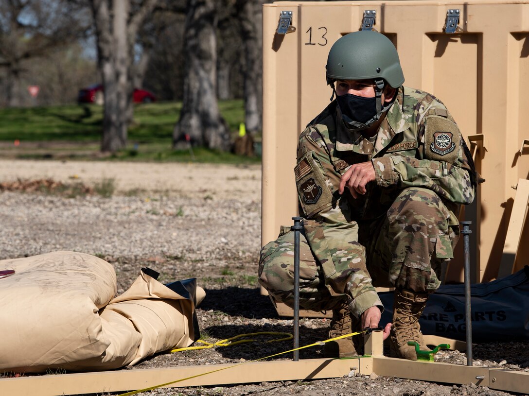 An Airman assembles a military shelter system