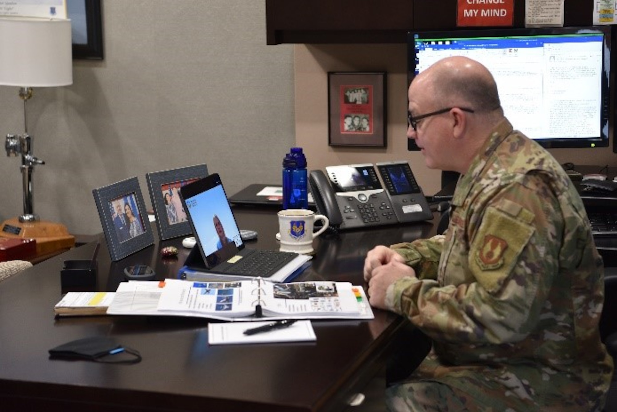 man sitting at desk talking to virtual audience