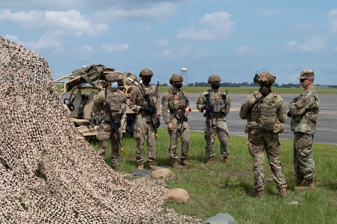 A photo of Airmen standing next to a man-made fort.