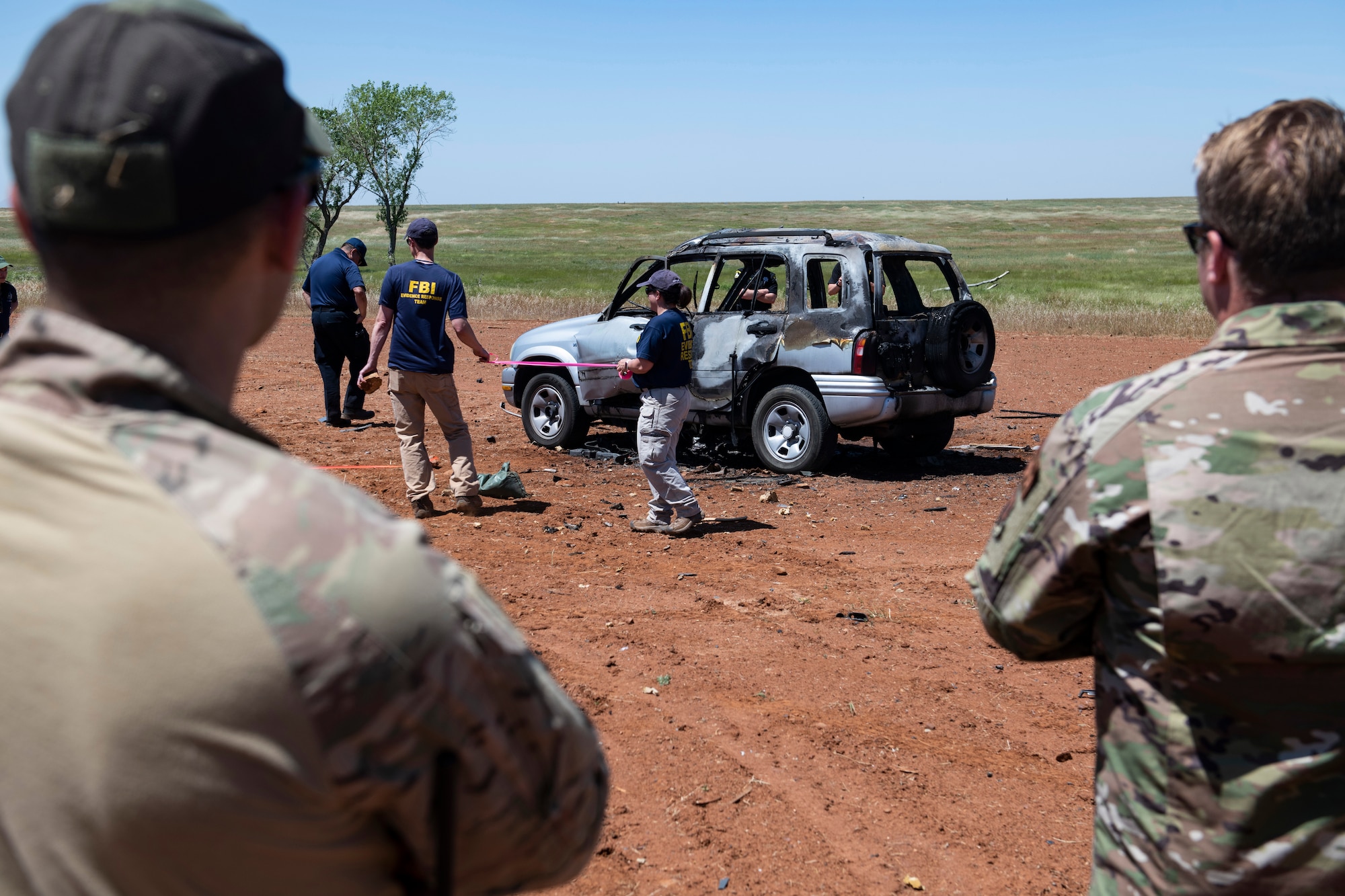 U.S. Air Force members watch as FBI special agents demonstrate how they would grid an area for a post-blast investigation.