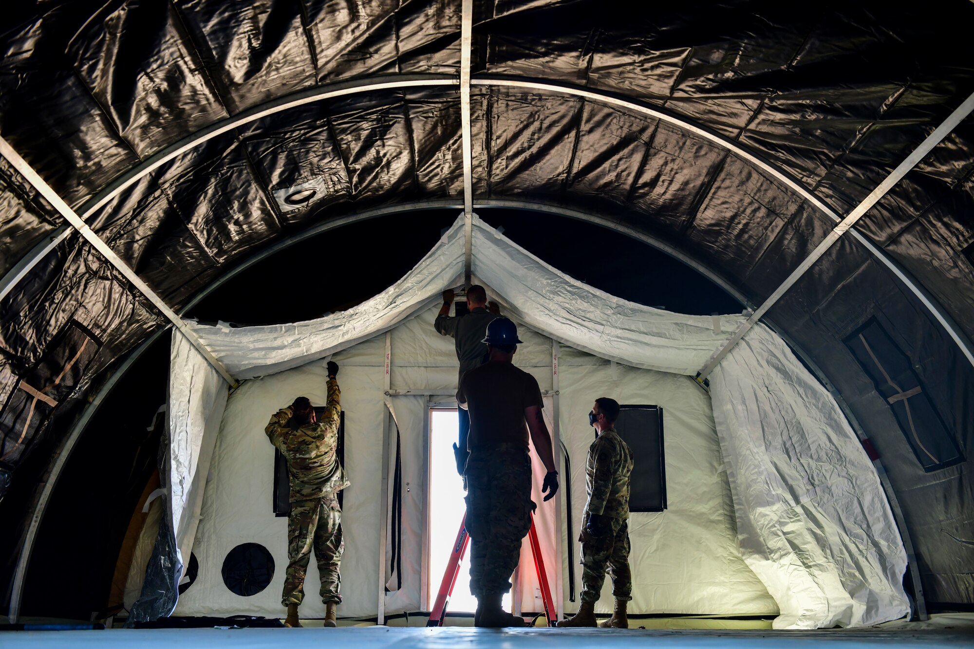 Airmen set up a military shelter system