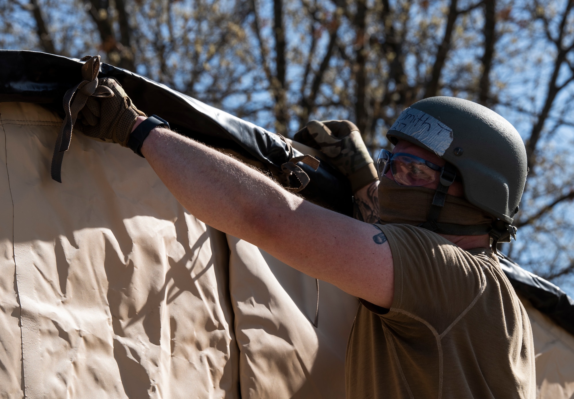 An Airman assembles a military shelter system