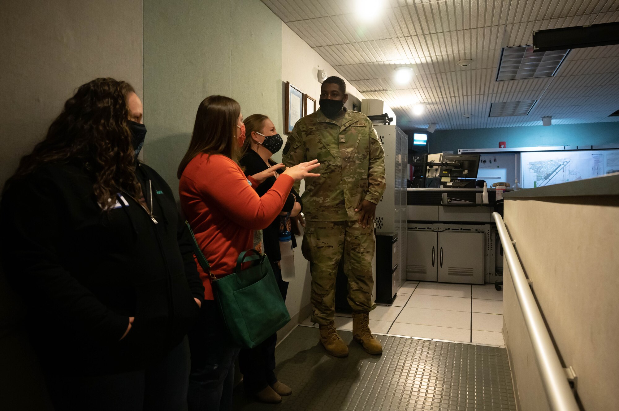 Senior Airman Sterling Tate, right, 341st Civil Engineer Squadron firefighter, escorts military spouses into the Base Defense Operations Center during a tour May 7, 2021, at Malmstrom Air Force Base, Mont.