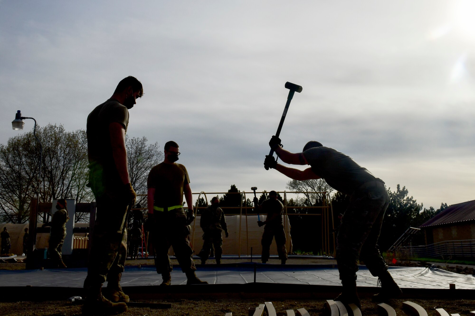 Airmen assigned to the 19th Airlift Wing stake down a military shelter system