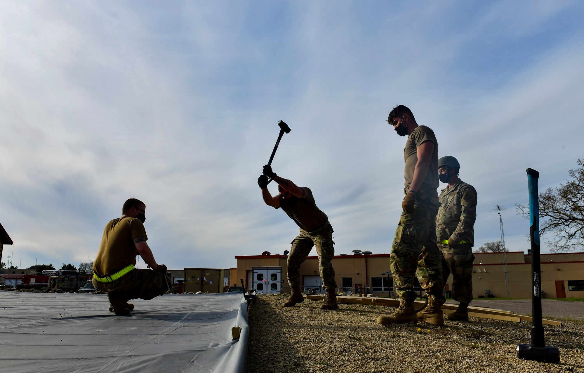 Airmen assigned to the 19th Airlift Wing stake down a military shelter system