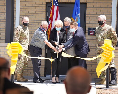 A group of people cutting a ribbon