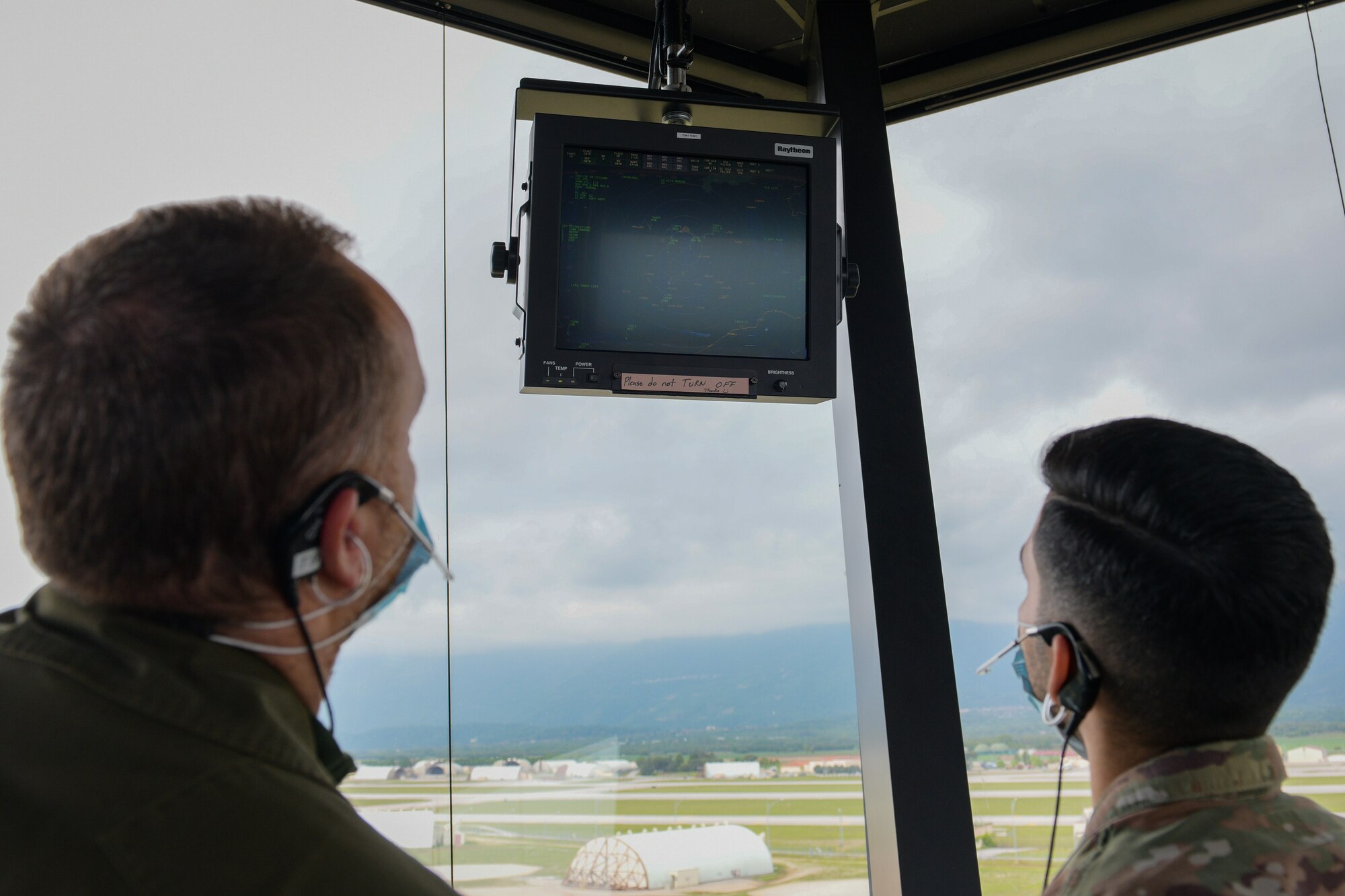 Italian air force Maresciallo Francesco Di Maggio, Air Traffic Control Service, air traffic controller (ATC), left, and U.S. Air Force Staff Sgt. Daniel Cabezas, 31st Operations Support Squadron ATC, review flight data in the Air Traffic Control Tower at Aviano Air Base, Italy, May 7, 2021. ATCs plot aircraft positions on radar equipment and compute aircraft speed, direction and altitude. The U.S. Air Force and ITAF ATCs work together to relay flight and landing instructions, weather updates, and safety information to the pilots. (U.S. Air Force photo by Airman 1st Class Brooke Moeder)