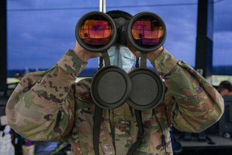 U.S. Air Force Staff Sgt. Daniel Cabezas, 31st Operations Support Squadron (OSS) air traffic controller, scans the horizon for landing lights and obstructions on the flight line at Aviano Air Base, Italy, May 7, 2021. The ATCs observe aircraft in their airspace and monitor different variables such as wind speed and altitude. The 31st OSS provides current operations planning, air traffic control, airfield management and weather and intelligence support. (U.S. Air Force photo by Airman 1st Class Brooke Moeder)