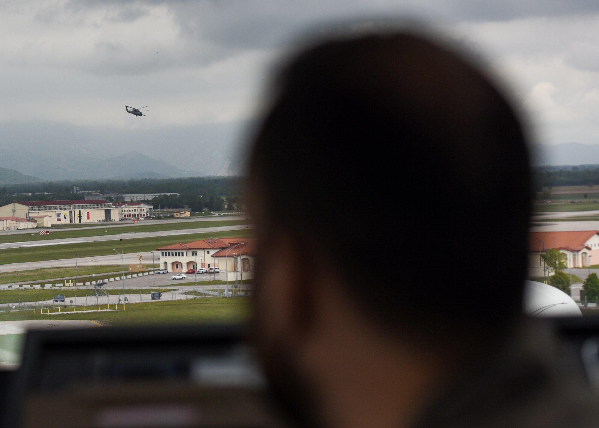Italian air force Maresciallo Gianluca Farina, Air Traffic Control Service, air traffic controller (ATC), watches an HH-60 Pave Hawk takeoff from the Air Traffic Control Tower at Aviano Air Base, Italy, May 7, 2021. ATCs plot aircraft positions on radar equipment and compute aircraft speed, direction and altitude. ATCs ensure the safety of the pilots, aircraft and civilians on the ground by staying vigilant and spotting complications before they happen. (U.S. Air Force photo by Airman 1st Class Brooke Moeder)