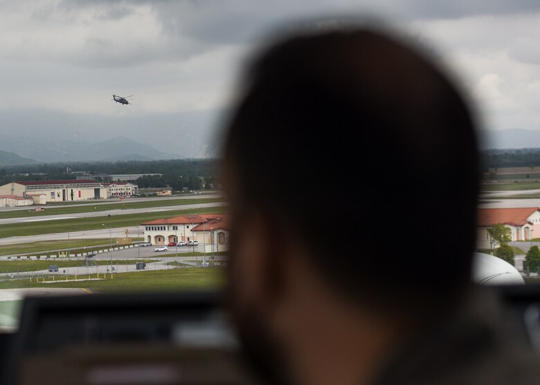 Italian air force Maresciallo Gianluca Farina, Air Traffic Control Service, air traffic controller (ATC), watches an HH-60 Pave Hawk takeoff from the Air Traffic Control Tower at Aviano Air Base, Italy, May 7, 2021. ATCs plot aircraft positions on radar equipment and compute aircraft speed, direction and altitude. ATCs ensure the safety of the pilots, aircraft and civilians on the ground by staying vigilant and spotting complications before they happen. (U.S. Air Force photo by Airman 1st Class Brooke Moeder)