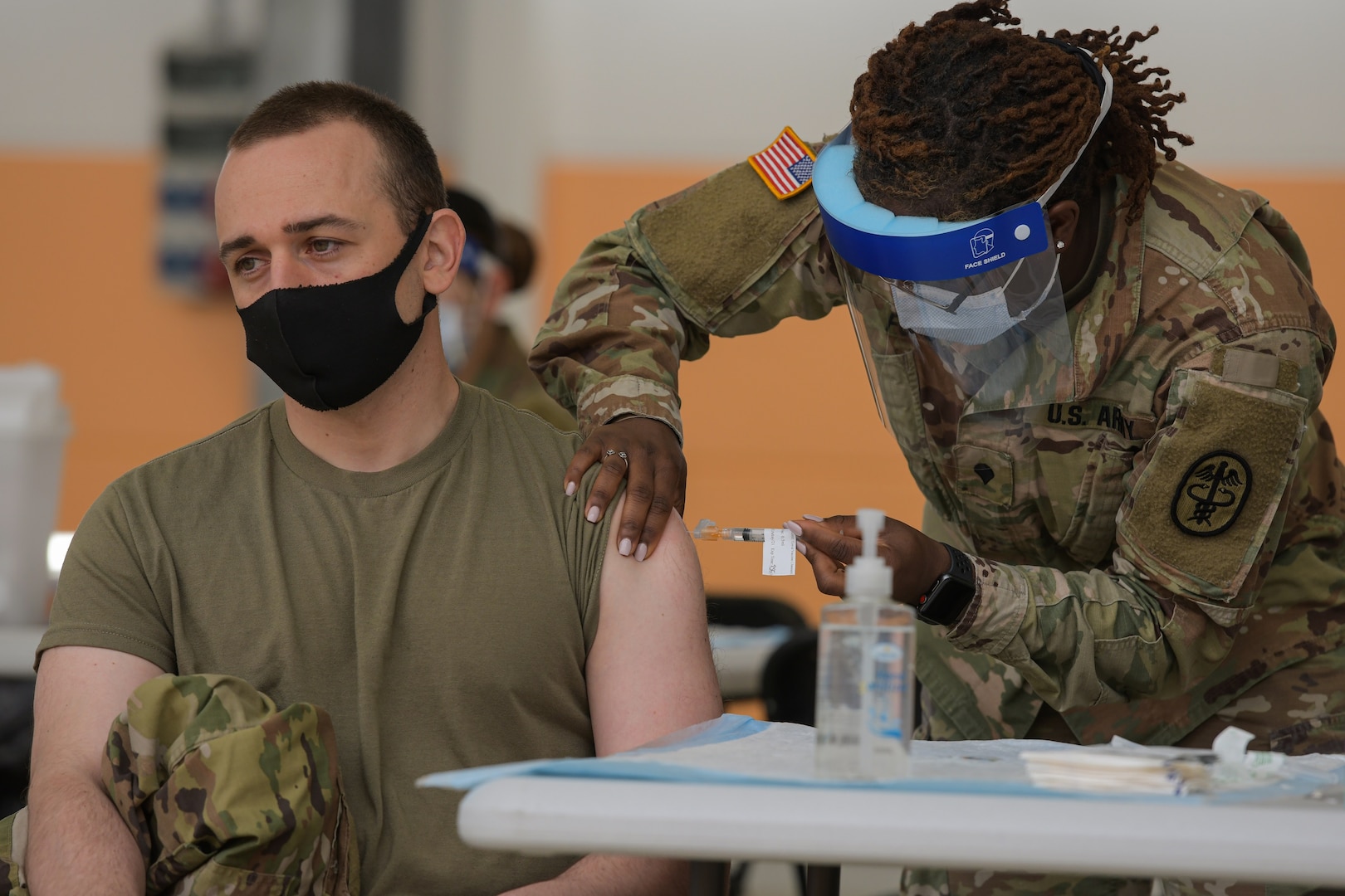 U.S. Army Cpl. Michael Lesser, left, with 3rd Squadron, 2nd Cavalry Regiment, receives a COVID-19 vaccination at the 7th Army Training Command's (7ATC) Rose Barracks, Vilseck, Germany, May 3, 2021. The U.S. Army Health Clinics at Grafenwoehr and Vilseck conducted a "One Community" COVID-19 vaccine drive May 3-7 to provide thousands of appointments to the 7ATC community of Soldiers, spouses, Department of the Army civilians, veterans and local nationals employed by the U.S. Army.