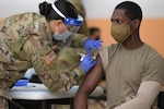 U.S. Army Spc. Eyza Carrasco, left, with 2nd Cavalry Regiment, administers a COVID-19 vaccination at the 7th Army Training Command's (7ATC) Rose Barracks, Vilseck, Germany, May 3, 2021. The U.S. Army Health Clinics at Grafenwoehr and Vilseck conducted a "One Community" COVID-19 vaccine drive May 3-7 to provide thousands of appointments to the 7ATC community of Soldiers, spouses, Department of the Army civilians, veterans and local nationals employed by the U.S. Army.