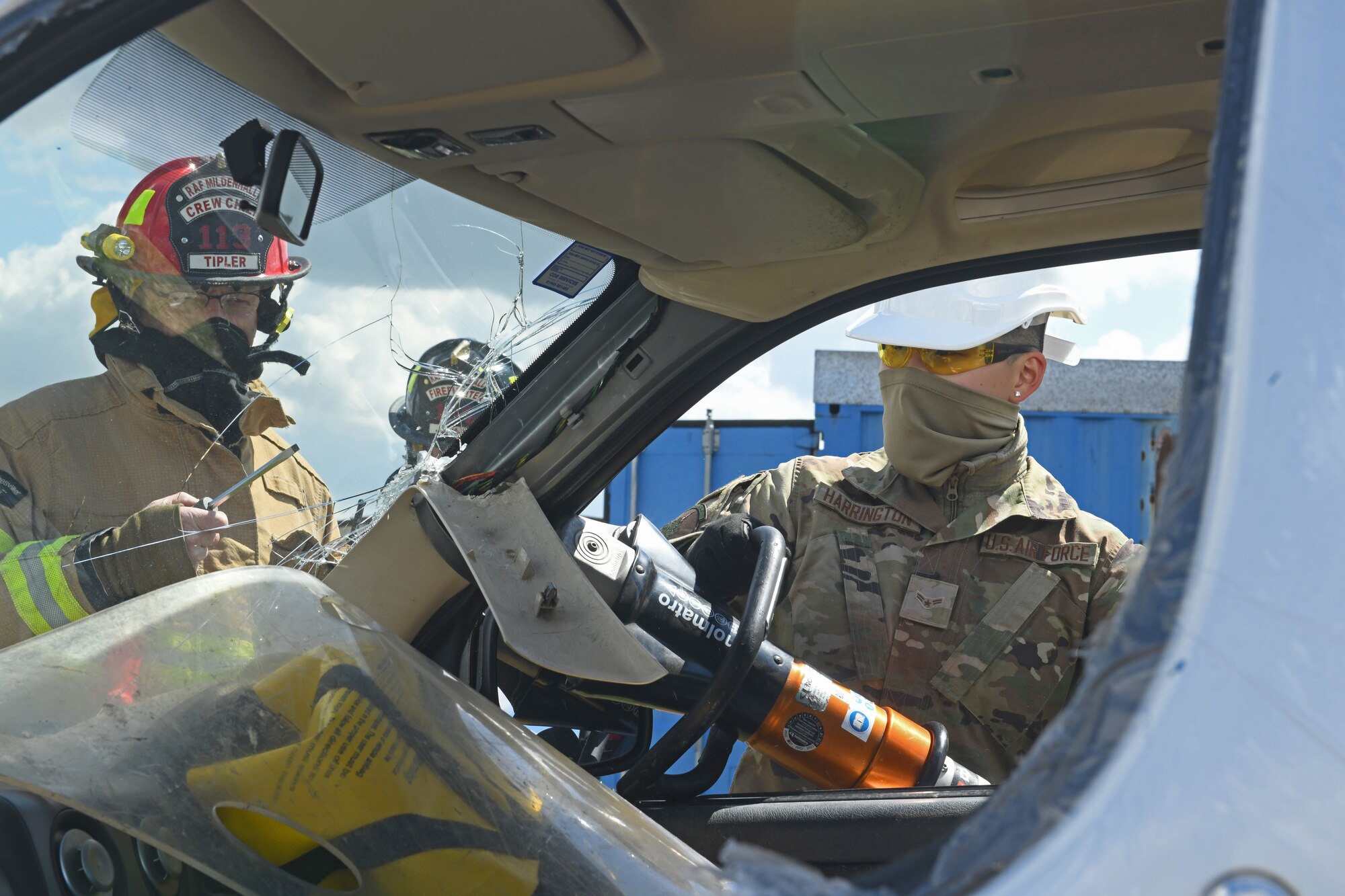 U.S. Airman 1st Class Bayli Harrington, 100th Logistics Readiness Squadron ground transportation operator, cuts open a vehicle door during training with the 100th Civil Engineer Squadron fire department at Royal Air Force Mildenhall, England, May 7, 2021. Firefighters trained LRS vehicle operators on how to properly cut open a vehicle while ensuring passenger safety. (U.S. Air Force photo by Staff Sgt. Mackenzie Mendez)