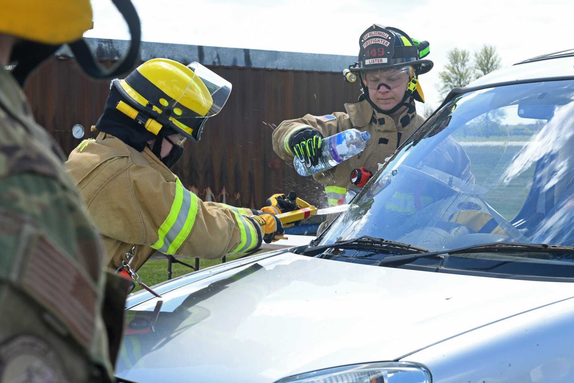 Firefighters assigned the 100th Civil Engineer Squadron cut open the windshield of a simulated crashed vehicle during training with the 100th Logistics Readiness Squadron at Royal Air Force Mildenhall, England, May 7, 2021. Firefighters demonstrated various ways to remove passengers from a crashed vehicle, including through the door and windshield. (U.S. Air Force photo by Staff Sgt. Mackenzie Mendez)